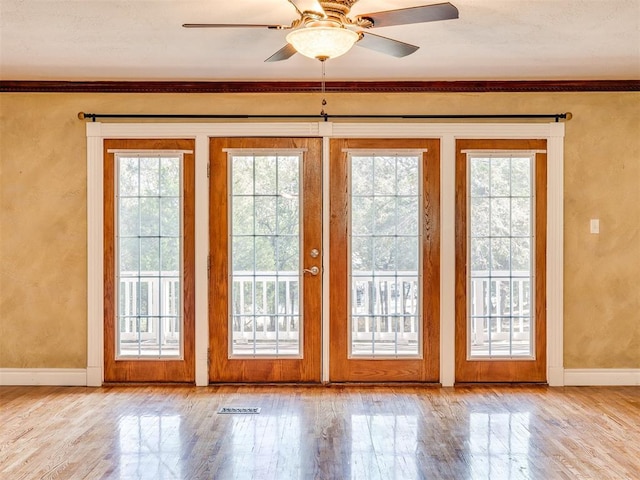 doorway featuring a wealth of natural light, light hardwood / wood-style flooring, and ceiling fan