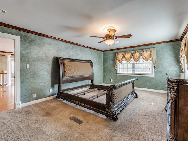 carpeted bedroom with ceiling fan, ornamental molding, and ornate columns