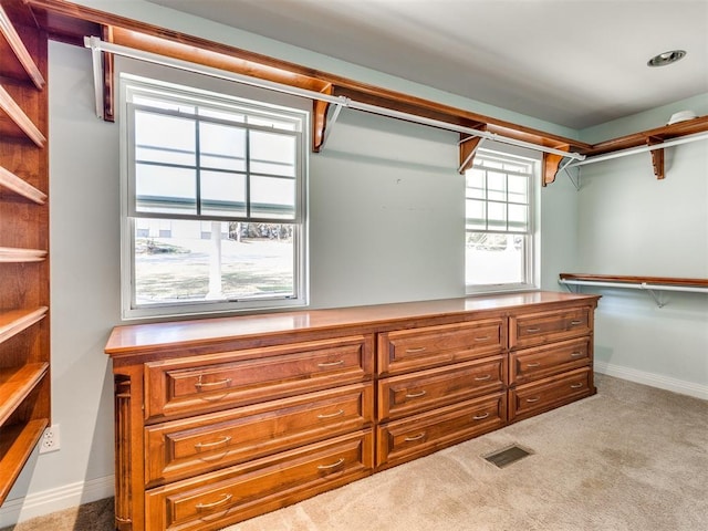 walk in closet featuring light carpet