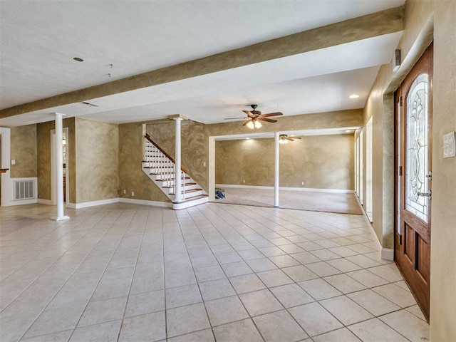 unfurnished living room with ceiling fan, beam ceiling, light tile patterned flooring, and decorative columns