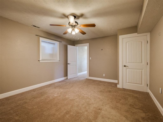 unfurnished bedroom with carpet flooring, a textured ceiling, and ceiling fan