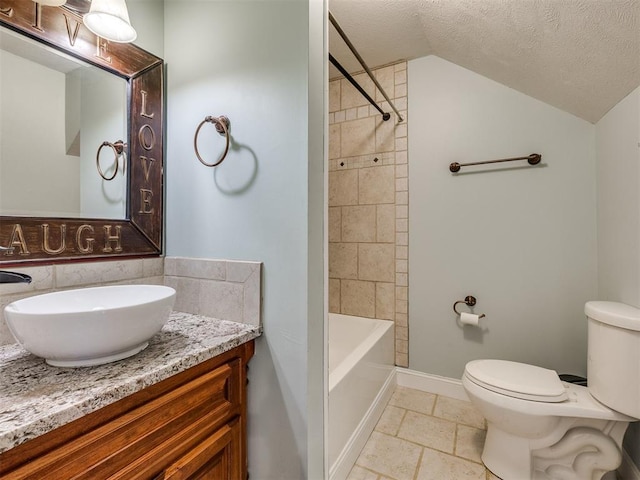 full bathroom featuring vanity, lofted ceiling, tiled shower / bath combo, toilet, and a textured ceiling