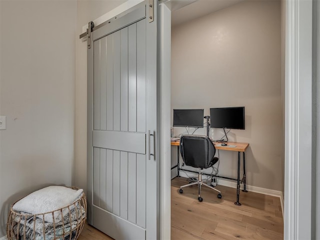 office area featuring a barn door and light hardwood / wood-style flooring