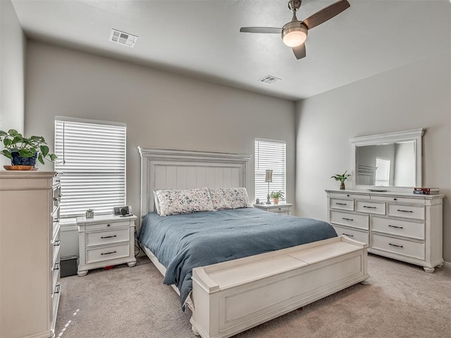 carpeted bedroom featuring ceiling fan and multiple windows