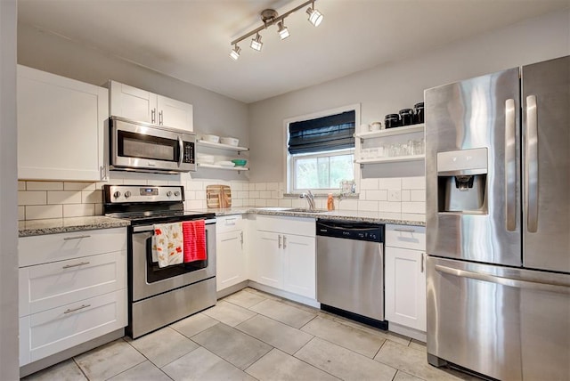 kitchen featuring open shelves, backsplash, appliances with stainless steel finishes, and white cabinetry