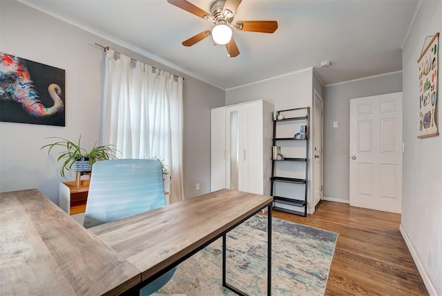 home office featuring ceiling fan, baseboards, wood finished floors, and crown molding