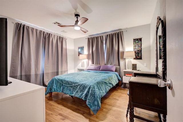 bedroom featuring visible vents, light wood finished floors, and ceiling fan