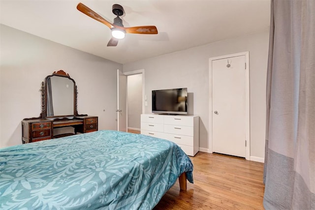 bedroom featuring baseboards, light wood-style flooring, and a ceiling fan