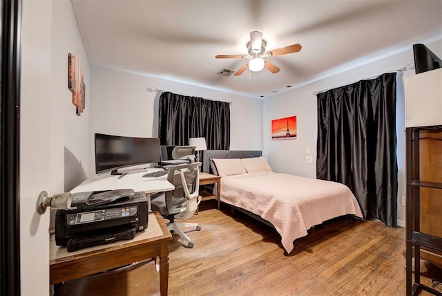 bedroom with light wood-style flooring, a ceiling fan, and visible vents