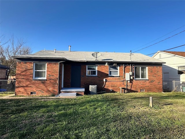 view of front facade with a front yard, fence, crawl space, central air condition unit, and brick siding