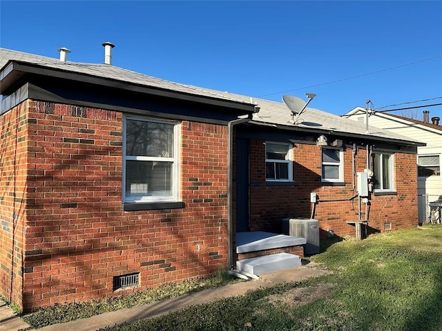 view of property exterior with central air condition unit, brick siding, and crawl space