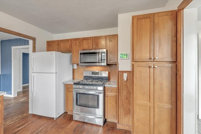 kitchen featuring light stone countertops, stainless steel appliances, and dark hardwood / wood-style floors