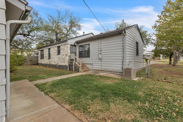 view of front of home with cooling unit and a front lawn