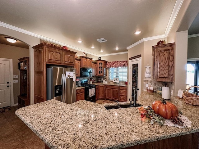 kitchen with kitchen peninsula, a wealth of natural light, black appliances, and decorative backsplash