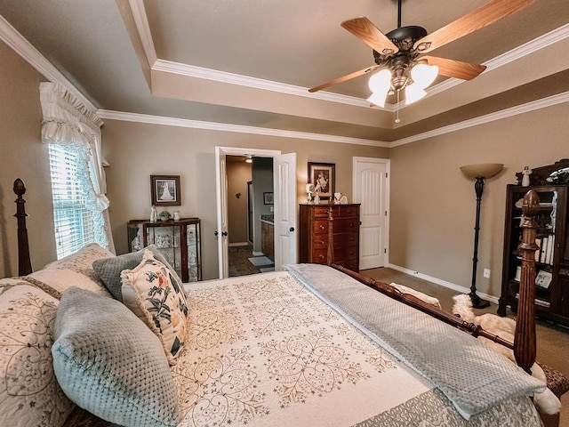 bedroom with ensuite bath, ceiling fan, a raised ceiling, carpet floors, and ornamental molding