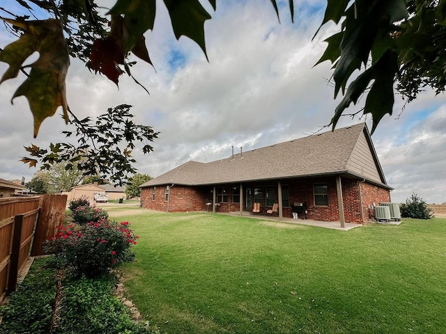 back of house with a patio, central air condition unit, and a lawn