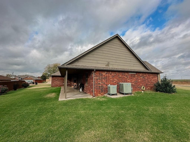 view of side of property with cooling unit, a yard, and a patio