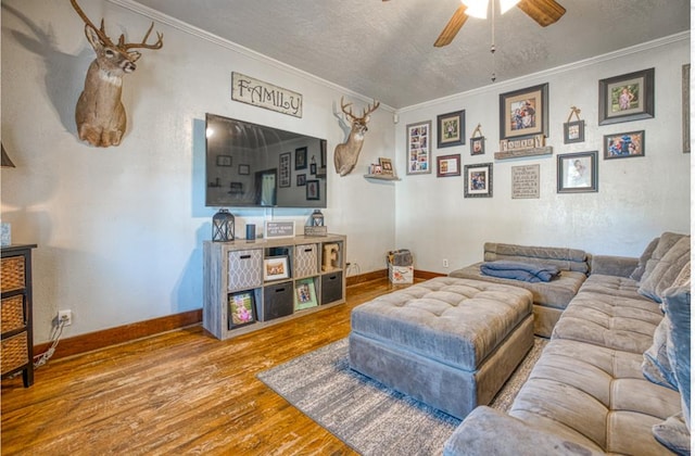 living room with ceiling fan, wood-type flooring, and crown molding