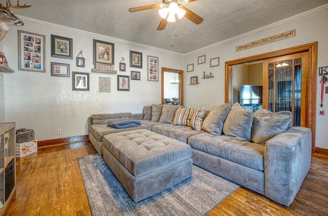 living room featuring hardwood / wood-style floors, a textured ceiling, ceiling fan, and crown molding