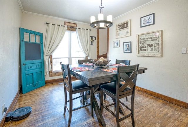 dining area featuring an inviting chandelier, ornamental molding, and hardwood / wood-style flooring