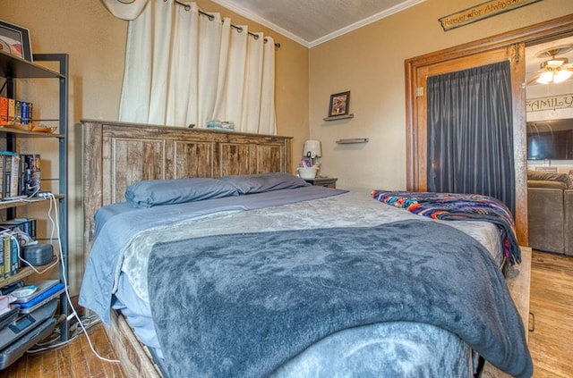 bedroom featuring wood-type flooring and ornamental molding