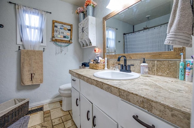 bathroom with a shower with shower curtain, vanity, and toilet