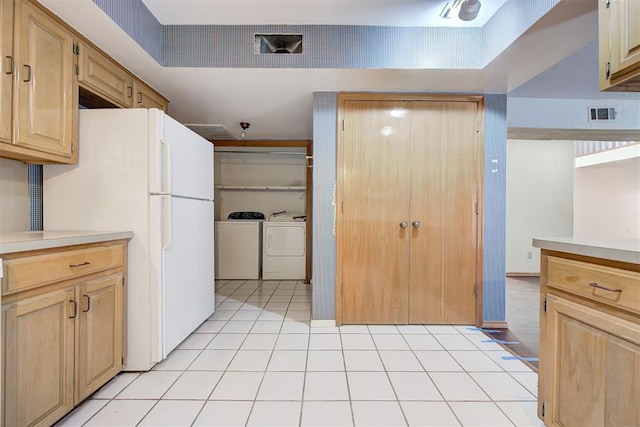 kitchen featuring light brown cabinetry, washing machine and dryer, white refrigerator, and light tile patterned flooring