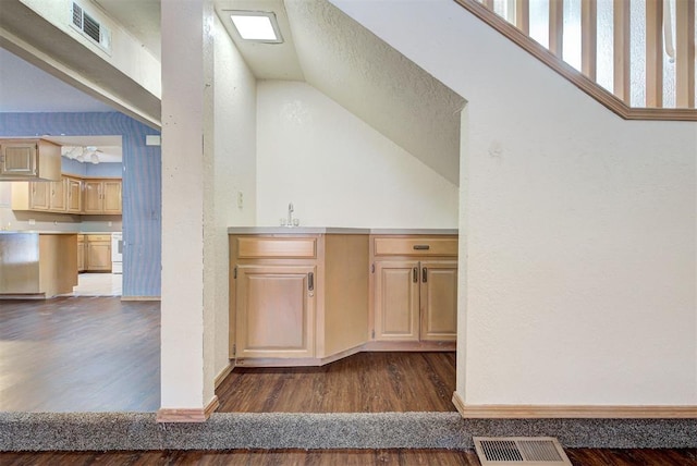 kitchen with light brown cabinets, dark hardwood / wood-style floors, vaulted ceiling, and sink