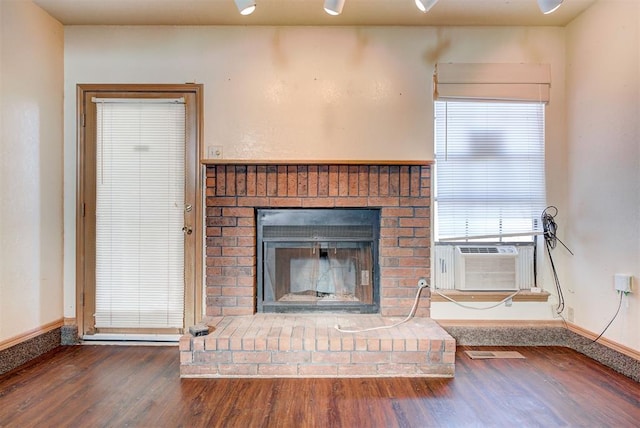 interior details featuring wood-type flooring, a brick fireplace, and cooling unit