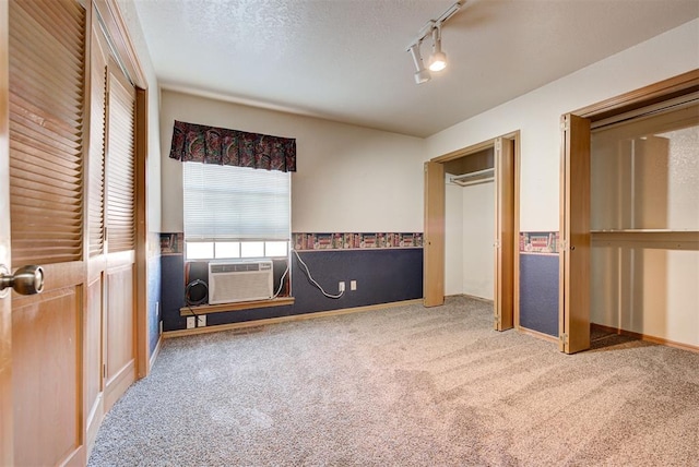 unfurnished bedroom featuring carpet flooring, a closet, and track lighting