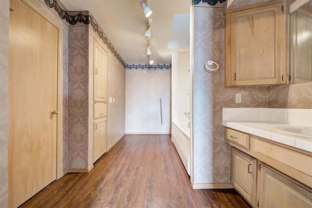 kitchen with tile countertops, track lighting, sink, light brown cabinetry, and dark hardwood / wood-style flooring