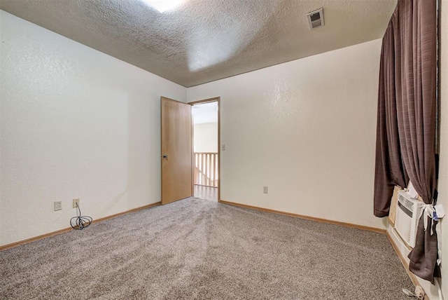 carpeted spare room with a textured ceiling