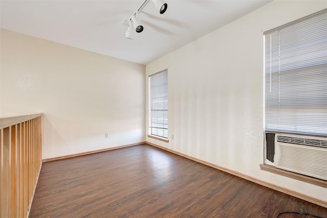 empty room with dark wood-type flooring and track lighting