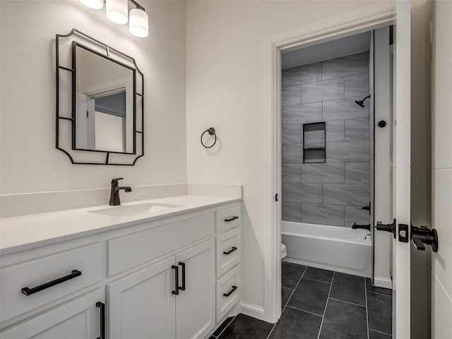 full bathroom featuring vanity, toilet, tiled shower / bath combo, and tile patterned flooring