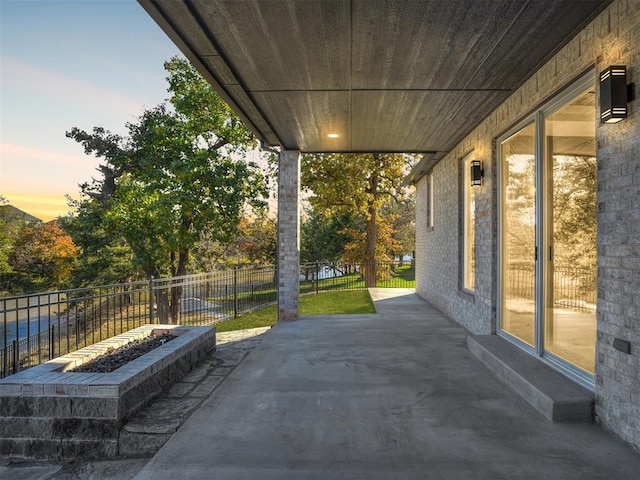 patio terrace at dusk featuring an outdoor fire pit