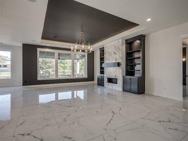 unfurnished living room with a notable chandelier, a wealth of natural light, and a raised ceiling