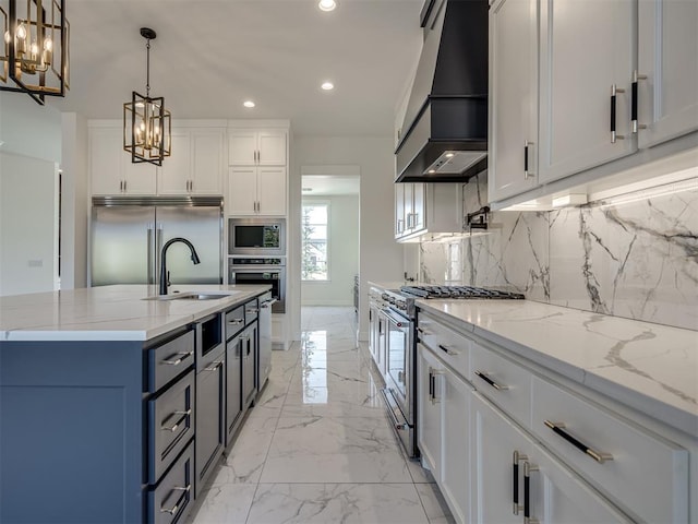 kitchen featuring premium range hood, white cabinetry, built in appliances, light stone counters, and decorative light fixtures