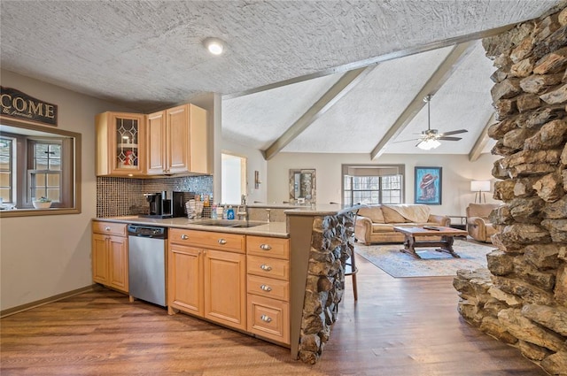 kitchen with sink, stainless steel dishwasher, a textured ceiling, tasteful backsplash, and wood-type flooring