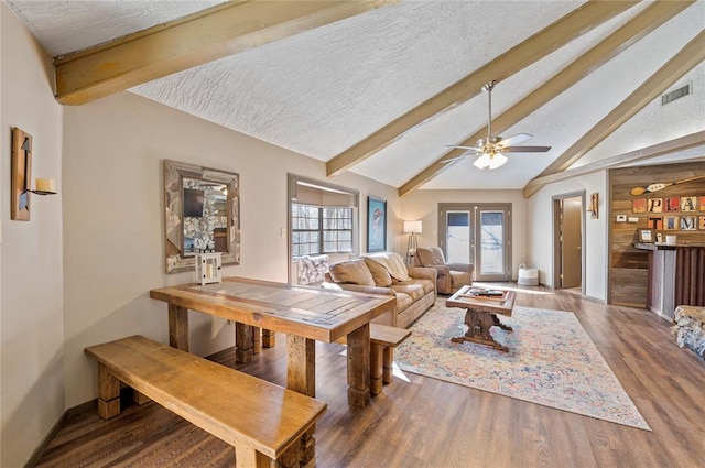 dining room featuring french doors, a textured ceiling, ceiling fan, wood-type flooring, and lofted ceiling with beams