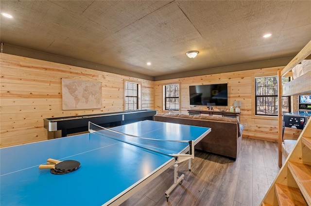 game room featuring hardwood / wood-style floors and wooden walls