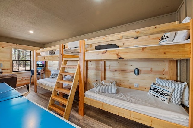 bedroom featuring wooden walls and wood-type flooring