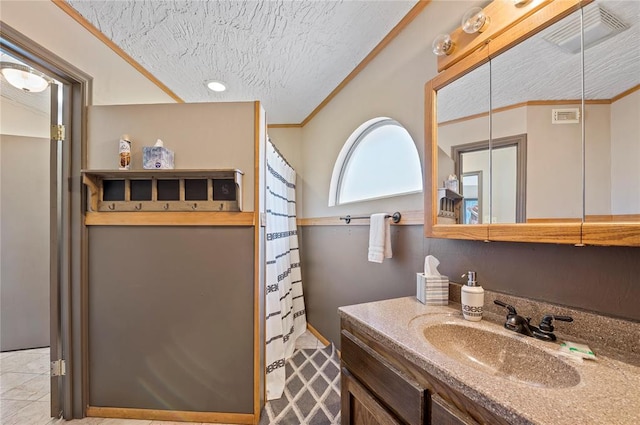 bathroom featuring tile patterned floors, vanity, crown molding, and a textured ceiling