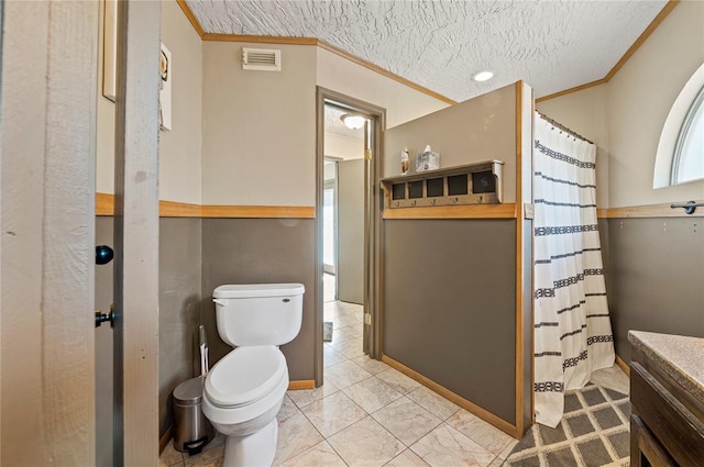 bathroom with a shower with curtain, toilet, a textured ceiling, and ornamental molding