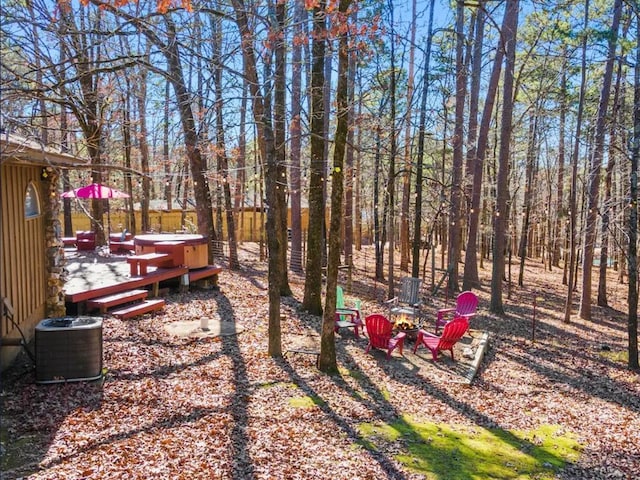 view of yard featuring central AC unit, a hot tub, and a deck