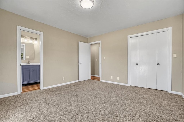 unfurnished bedroom featuring a closet, carpet flooring, connected bathroom, and baseboards