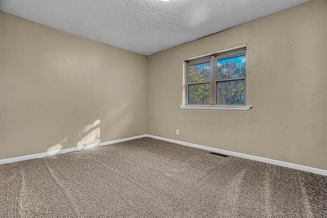 carpeted spare room featuring a textured ceiling, a textured wall, visible vents, and baseboards