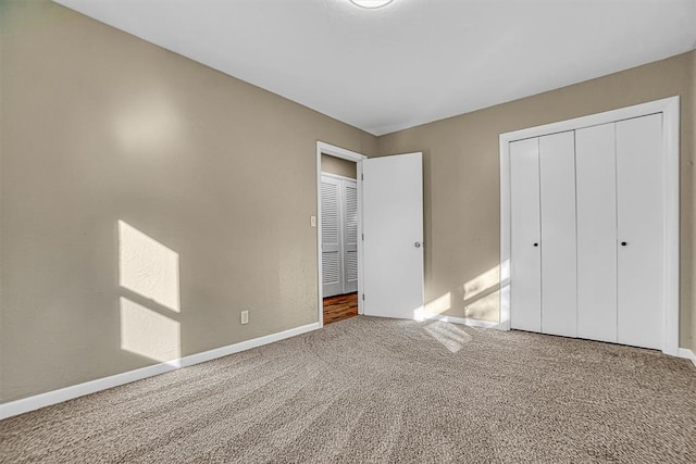 unfurnished bedroom featuring a closet, baseboards, and carpet flooring