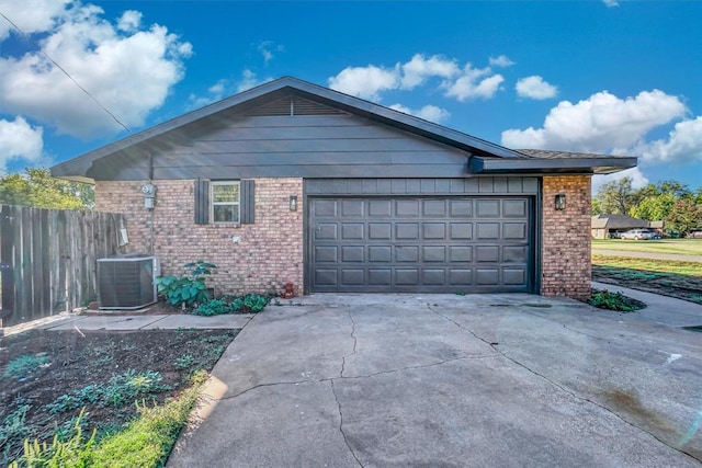 view of side of home with concrete driveway, fence, cooling unit, and brick siding