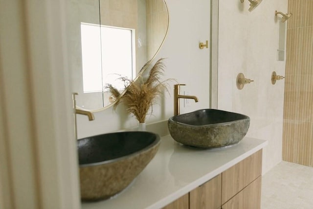 bathroom with tile patterned flooring, vanity, and walk in shower