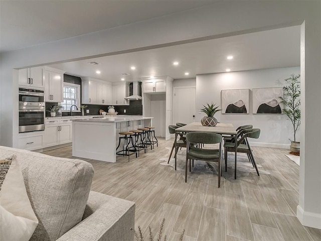 dining space featuring light wood-type flooring and sink